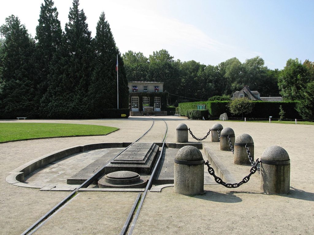 Monument of the Compiègne Wagon, the place where the armistice of Germany was signed, marking the end of WWI. The picture shows rails and the concrete shrine marking the place of the wagon. (CC-BY-SA MagentaGreen via Wikimedia)