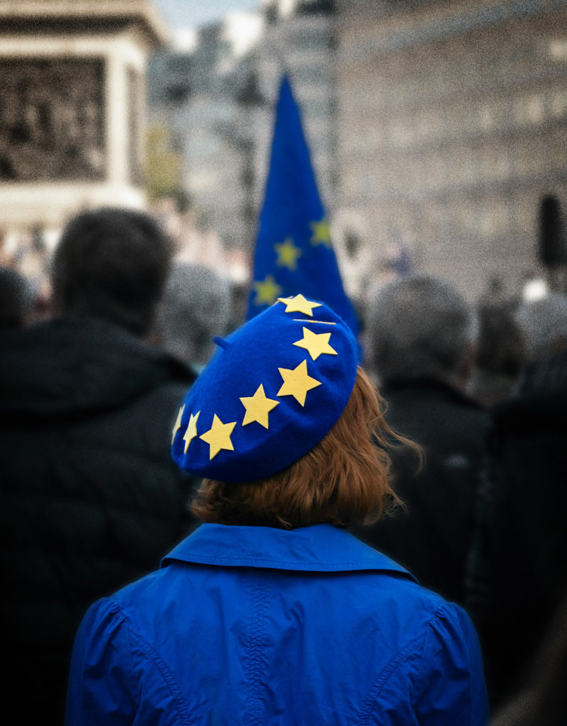 Frau mit Europamütze und blauem Mantel bei Demo